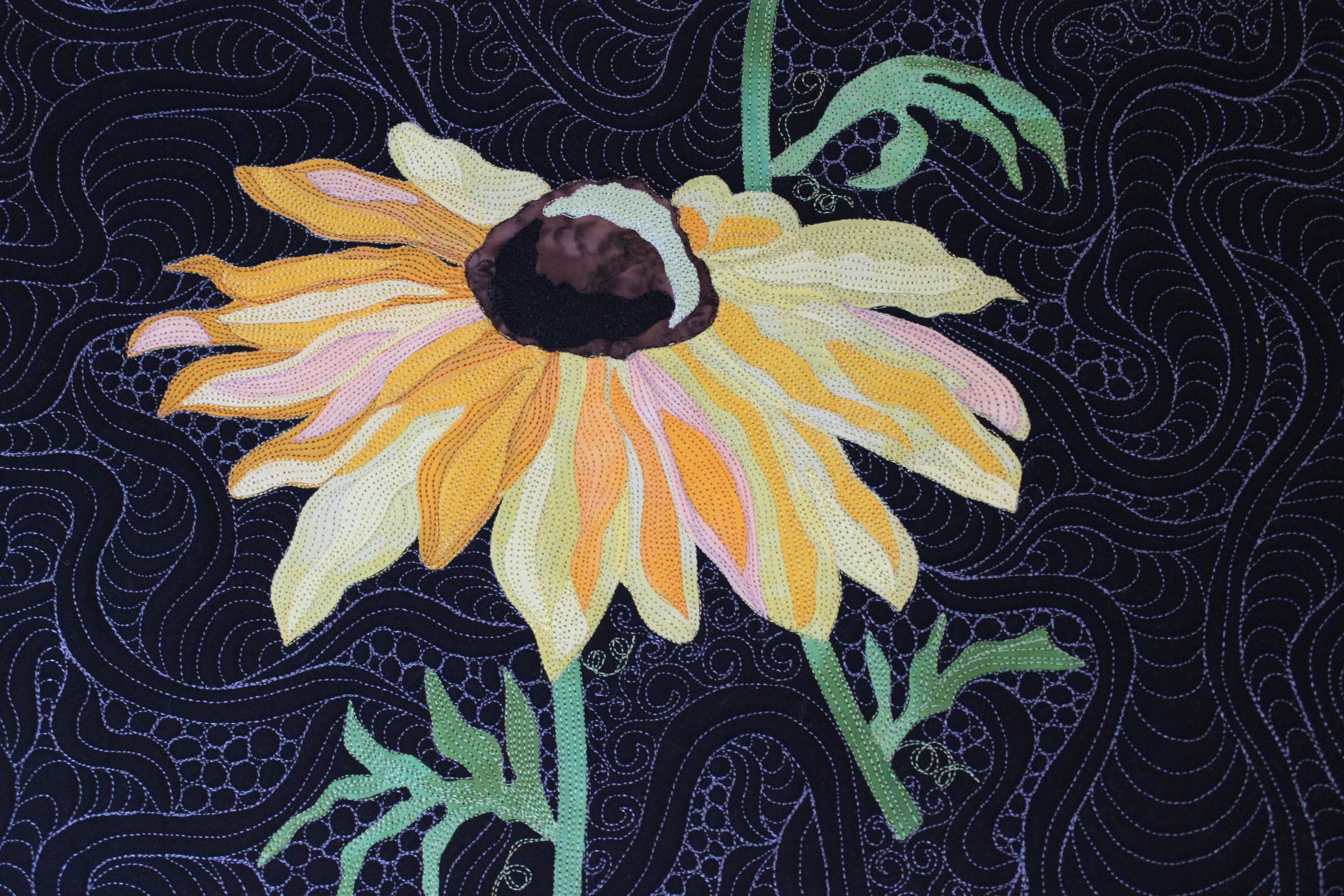 Quilt depicting the flower Rudbeckia hirta (Black-eyed susan) on a dark background.