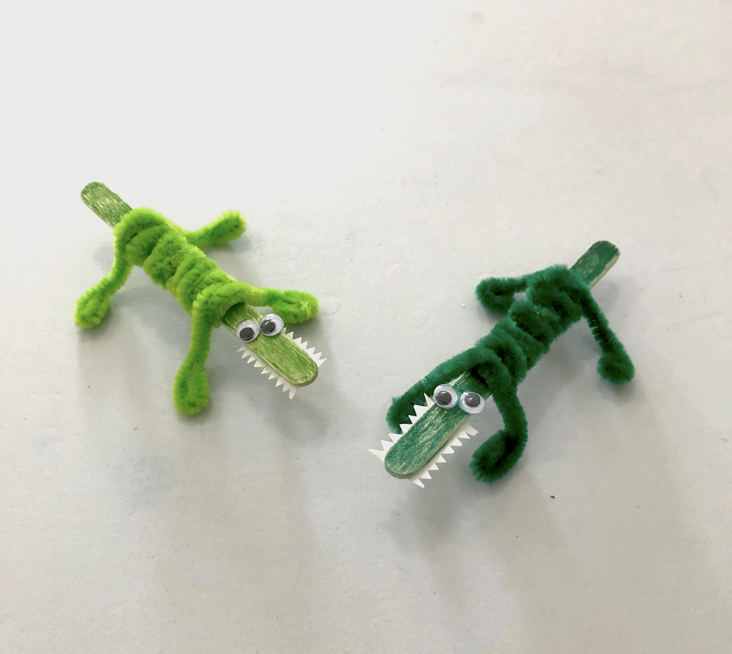 Photo depicting alligator craft made out of pipe cleaners and popsicle sticks.