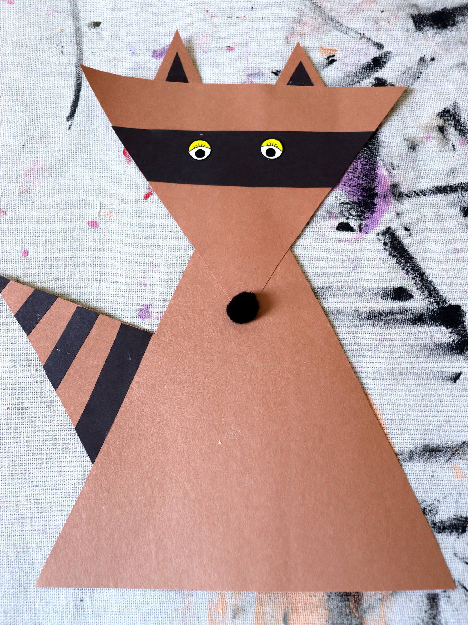 Photo depicting a raccoon craft made out of brown and black construction paper.